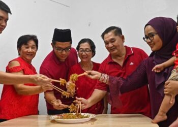 LEE Liang Yeow (tiga dari kiri) dan isterinya, Nurul Akma Roslin (kanan) meraikan sambutan Tahun Baharu Cina 2023 bersama keluarga menggaul Yee Sang di rumah mereka di Kuala Ibai, Kuala Terengganu, semalam. - FOTO/PUTRA HAIRRY ROSLI