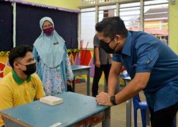 RADZI Jidin (kanan) meluangkan masa berbual dengan calon Sijil Pelajaran Malaysia (SPM), Muhammad Adib Baihaqi Khairu Riduan di Sekolah Menengah Kebangsaan (SMK) Sultan Sulaiman di Kuala Terengganu, hari ini. - FOTO/PUQTRA HAIRRY ROSLI