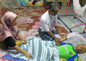 AB. Rahman Kadir dan Kalsom Salleh terpaksa menjaga Norman Hakim yang mengidap Cerebral Palsy di rumah mereka di Kampung  Titian Baru, Kuala Terengganu, hari ini. - FOTO/KAMALIZA KAMARUDDIN