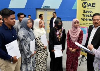 DR. FADZLI Adam (kanan) dan Ahmad Farid Qoureshmi Md. Daud (dua dari kanan) beramah mesra dengan sebahagian pelajar yang menerima sumbangan dermasiswa Maybank di UniSZA, Kuala Nerus, Terengganu, hari ini. - FOTO/KAMALIZA KAMARUDDIN