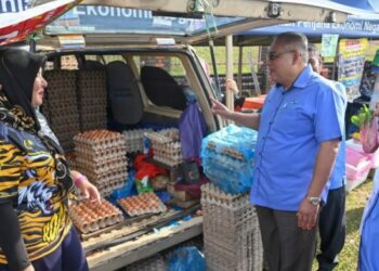 ZAINAL Abidin Yang Razalli (tengah) bertanyakan sesuatu kepada seorang peniaga  ketika meninjau JTDLKM di Tapak Pasar Malam Medan Jaya, Rusila, Marang, hari ini. - FOTO/PUQTRA HAIRRY ROSLI