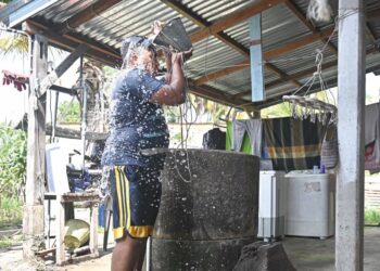 MUHAMMAD Sharil Mohd. Sabri terpaksa mandi menggunakan air perigi selepas berlaku gangguan bekalan air untuk menyejukkan badan berikutan cuaca panas di Kampung Baru, Kelulut, Rhu Muda, Marang, Terengganu. - UTUSAN/ PUQTRA HAIRRY ROSLI