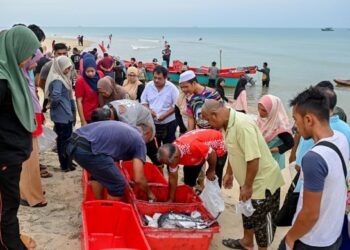 ORANG ramai memilih ikan segar untuk dibeli hasil tangkapan nelayan di Pantai Telaga Papan, Setiu, Terengganu, semalam. - UTUSAN/PUQTRA HAIRRY ROSLI