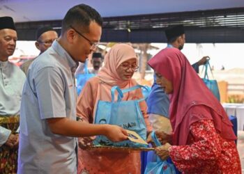 NIK Nazmi Nik Ahmad menyampaikan sumbangan kepada salah seorang golongan asnaf pada Majlis Iftar Ramadan di Kuala Terengganu, semalam. – FOTO/PUQTRA HAIRRY ROSLI