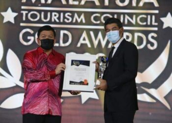 TENGKU Ahmad Nadzri Tengku Musa (kanan) menerima trofi dan sijil Inisiatif Eko Pelancongan Terbaik dalam Anugerah Emas Majlis Pelancongan Malaysia 2021 yang diadakan di ibu kota semalam.