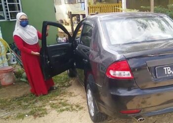 SAPIAH Omar menunjukkan cermin keretanya yang dipecah penjenayah ketika diparkir di Jalan Pak Dagang, Dungun, Terengganu semalam. - FOTO/NIK NUR IZZATUL HAZWANI NIK ADNAN