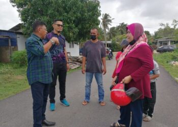 HANAFIAH Mat berbincang dengan keluarga yang terjejas akibat hakisan pantai di Kampung Geliga Baru di Kemaman, semalam. - UTUSAN/NIK NUR IZZATUL HAZWANI NIK ADNAN