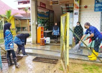 SUKARELAWAN USIM membersihkan lumpur di Sekolah Kebangsaan Air Putih, Kemaman hari ini.