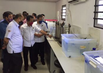 HAFIZAN Juhair (tengah) menunjukkan alat pengekstrakan minyak gelam kepada Ahmad Amzad Hashim (kiri) di Unisza, Kuala Nerus, Terengganu, hari ini. - FOTO/TENGKU DANISH BAHRI TENGKU YUSOF