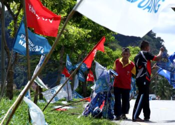 Penduduk Dataran Sunway Tambun, Perak  menurunkan bendera parti politik setelah berakhirnya PRU15, semalam. - UTUSAN/MUHAMAD NAZREEN SYAH MUSTHAFA