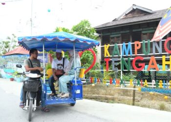 Pengunjung boleh menikmati keindahan perkampungan nelayan dengan menaiki tuk tuk di tapak Program Transformasi Diraja Kampung Nelayan Warna-Warni Seberang Ramai Kuala Perlis. – UTUSAN/IZLIZAN OTHMAN