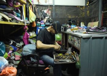 SHAHIDIN Ramli, 55, merupakan satu-satunya tukang kasut di negeri ini yang beroperasi pada waktu malam.- UTUSAN/IZLIZAN OTHMAN