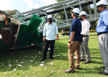 KHAIRUL Shahril Mohamed (kiri) bersama ahli jawatankuasa surau meninjau keadaan menara telekomunikasi yang tumbang akibat ribut di Surau Diri Jumaat Al-Ansar di Bandar Seri Botani di Ipoh, Perak. - UTUSAN/LIYANA RAMLI