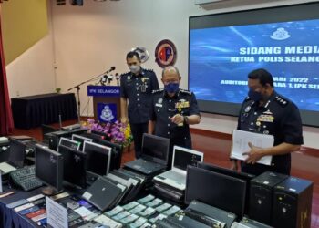 ARJUNAIDI Mohamed (tengah) menunjukkan sebahagian daripada peralatan komputer dan wang tunai digunakan untuk aktiviti perjudian dirampas dalam sidang akhbar di IPK Selangor di Shah Alam, Selangor.