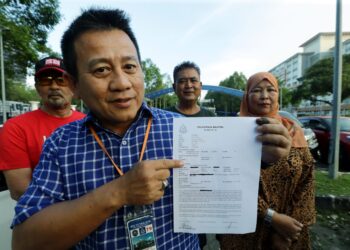 TUN Faisal Ismail Aziz menunjukkan laporan polis berkaitan surat Pengerusi BN yang didakwa cuba menipu Yang di-Pertuan Agong di IPD Putrajaya. - UTUSAN/FAISOL MUSTAFA