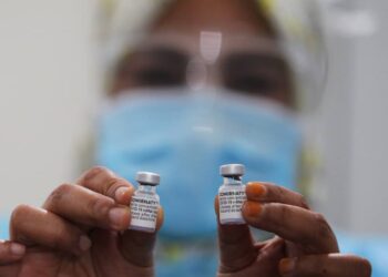 PETUGAS Jabatan Kesihatan Kelantan menunjukkan vaksin Covid-19 yang akan disuntik kepada penerima ketika proses pemvaksinan di PPV Wakaf Bharu, Tumpat, Kelantan. - UTUSAN/ZULHANIFA SIDEK