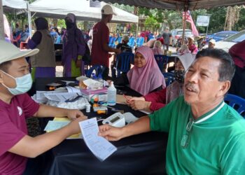 PENDUDUK  tidak melepaskan peluang menjalani pemeriksaan kesihatan pada Program Kesejahteraan Kesihatan Komuniti dan Alam Sekitar di Dataran Sungai Pengkalan Berangan, Marang, Terengganu, hari ini.  - UTUSAN/NOOR HAYATI MAMAT