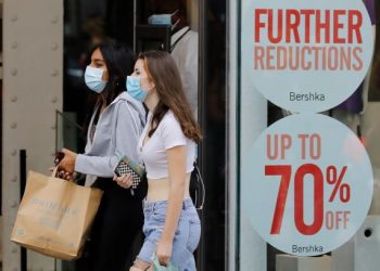 DUA wanita melalui gedung beli-belah di London yang menawarkan potongan harga untuk menarik pelanggan. Ekonomi UK berdepan krisis disebabkan pandemik Covid-19. – AFP