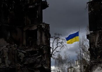 BENDERA Ukraine berkibar antara deretan bangunan yang musnah dibom di bandar Borodianka.-AFP