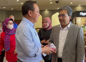JOHARI Abdul Ghani (kanan) berbual dengan Hasni Mohammad selepas menyerahkan borang pencalonan untuk bertanding jawatan Naib Presiden UMNO di Kuala Lumpur, semalam.