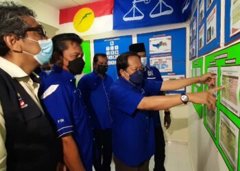 AHMAD Maslan melihat carta sewaktu melawat Bilik Gerakan BN PDM Bukit Terendak, Sungai Udang, Melaka. - UTUSAN/AMRAN MULUP