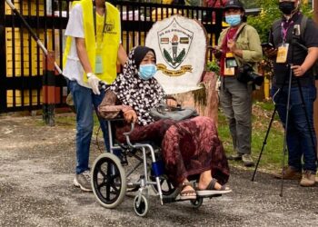 PETUGAS pusat mengundi PRN Melaka membantu seorang warga emas ke kaunter pendaftaran di SK Durian Daun, Lendu, Melaka hari ini.