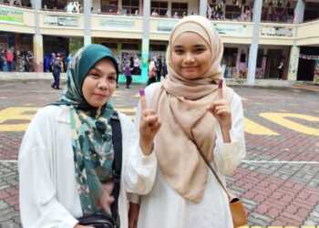 NUR Farisha Elina (kanan) bersama Sabahirah selepas mengundi di SK Puncak Alam 2, Kuala Selangor.-UTUSAN/ AFIQ RAZALI