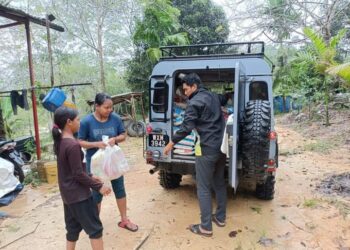 SEORANG kakitangan JKM menyerahkan bantuan bakul makanan kepada mangsa banjir yang terputus hubungan di RPS Buluh Nipis dan Kampung Ganoh di Rompin, Pahang - FOTO /IHSAN JKM ROMPIN