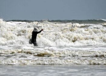 SEORANG nelayan menjala ikan di pesisir pantai dalam keadaan laut bergelora berikutan bermulanya Monsun Timur Laut sehingga Mac tahun depan di Pantai Pandak, Chendering, Terengganu, semalam. -UTUSAN/PUQTRA HAIRRY