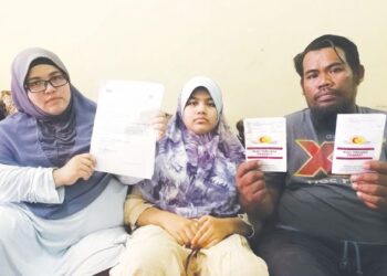 ENGKU Zuria Azura Engku Mat Arif bersama Ruzman Hamid  menunjukkan  dokumen rawatan kesihatannya dan anak, Nur Aisya Humaira di Kampung Batu Enam, Dungun, Terengganu, hari ini. - UTUSAN/NIK NUR IZZATUL HAZWANI NIK ADNAN
