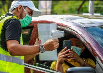 KAKITANGAN USIM memeriksa suhu badan semasa proses pendaftaran penuntut baharu program Tamhidi di Kolej Kediaman Nilam Court, USIM, Nilai, Negeri Sembilan hari ini.- UTUSAN/MUHAMMAD IZZAT TERMIZIE