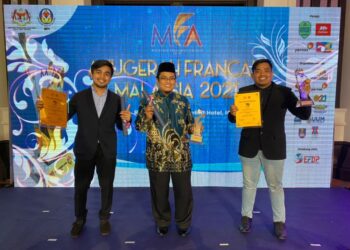 DR. ISMA Addi Jumbri (tengah) bersama Mohammad Muadzan Abd. Rahman (kiri) dan Muhammad Syafiq Abd. Talib menunjukkan sijil dan trofi selepas menjuarai Cabaran Niaga Francais Malaysia 2021 dan video montaj terbaik di Anugerah Francais Malaysia 2021.