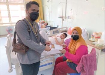 JOHAR Zainal Abidin (kiri) menyerahkan sumbangan kepada ibu Iskandar Zulqarnain Fadzil Azhar di Hospital Teluk Intan, Perak, kelmarin. - UTUSAN/IHSAN MAIPk