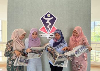 KAKITANGAN UCTATI membaca akhbar Utusan Malaysia yang diedarkan secara percuma di universiti kolej itu di Kemaman, Terengganu, hari ini.  - UTUSAN/NIK NUR IZZATUL HAZWANI NIK ADNAN