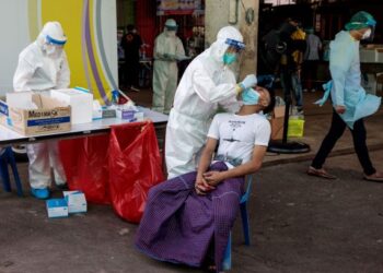 PETUGAS perubatan melakukan ujian Covid-19 terhadap penduduk di pasar makanan laut di Samut Sakhon, Thailand. - AFP
