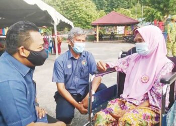 FIRDAUS Ahmad (kiri) dan Saiful Anwar Azmi bertanya khabar kepada Sepora Amin atau Tok Pora selepas
menerima suntikan vaksin pada Program Outreach Imunisasi Covid-19 di Pulau Tuba,
Langkawi, semalam.
