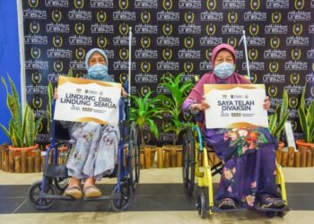 ZALILLAH Muda, 85, (kiri) selesai menerima suntikan vaksin Covid-19 bersama adiknya, Aminah, 80, di pusat pemberian vaksin (PPV) Universiti Sultan Zainal Abidin (Unisza) di Kuala Nerus.