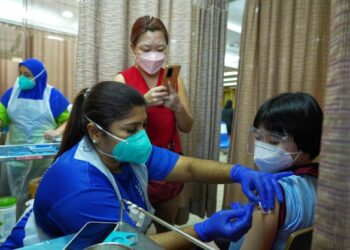 SEORANG remaja yang ditemani ibunya menerima suntikan dos kedua vaksin Pfizer di Hospital Pakar KPJ Tawakkal, Kuala Lumpur. – UTUSAN/MUHAMAD IQBAL ROSLI