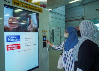 KUALA LUMPUR, 19 JULAI 2022: Pelajar kolej, Nurul Husna Nasir, 19 (kiri) bersama rakan, Allya NatashaMazlan, 19, membeli akhbar Utusan Malaysia dan Kosmo keluaran Media Mulia Sdn. Bhd. dari mesin layan diri di Stesen Transit Aliran Ringan (LRT) Bangsar. - UTUSAN/MUHAMAD IQBAL ROSLI