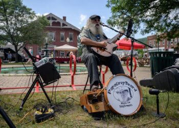 SEORANG pemuzik jalanan mengadakan persembahan di pasar tani di Northfield, Vermont yang kini kira-kira 82 peratus penduduknya sudah divaksin. - AFP