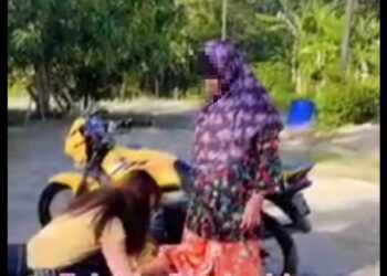 TANGKAP layar video dimuat naik ‘Faqih Faiqal’ yang menarik perhatian netizen memaparkan seorang gadis mengelap visor topi keledar menggunakan kain batik ibunya.
