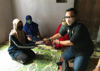 WAN Khairul Ihsan Wan Mohamad (kanan) menyampaikan bantuan kewangan kepada Wan Nur Atierah Wan Mohd. Nasrom di Kampung Bendang Pulau Palekbang, Tumpat, Kelantan,  hari ini. - UTUSAN/ROSLIZA MOHAMED