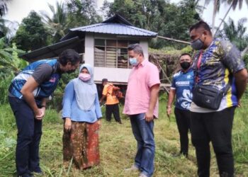 WAN Ahmad Fayshal Wan Ahmad Kamal (kiri) pada program menyantuni masyarakat di Kampung Parit Haji Napis di Bagan Serai, Perak, hari ini. - FOTO/WAT KAMAL ABAS