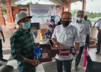 WAN Rosdy Wan Ismail (kanan) menyerahkan replika kunci projek Rumah Rakyat Pahang (RRP) yang bernilai RM65,000 kepada seorang penduduk yang kurang berkemampuan di Kampung Bukit Rang di Jerantut, Pahang. - FOTO/HARIS FADILAH AHMAD