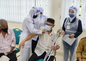 PETUGAS Unit Bergerak Vaksinasi Covid-19, Pejabat Daerah Kuantan melakukan proses pemberian vaksin dos kedua jenis Pfizer kepada penghuni Kompleks Asnaf Majlis Ugama Islam dan Adat Resam Melayu Pahang (Muip) di Kuantan, Pahang. - UTUSAN/ DIANA SURYA ABD WAHAB