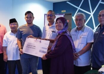 MUHAMMAD Amir Ashraf Hassan (tiga dari kiri) menyerahkan sumbangan RM10,000 kepada Zubaidah Zamri yang merupakan seorang daripada penerima sumbangan dan infak harta Hassan Johan di Taiping hari ini. - UTUSAN/WAT KAMAL ABAS