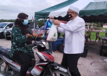 RAZMAN ZAKARIA menyampaikan sumbangan keperluan makanan kepada penduduk tiga buah kampung di Bagan Serai hari ini. - UTUSAN/WAT KAMAL ABAS