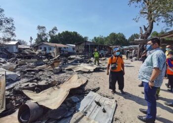 SHAHELMEY Yahya (kanan) mendengar penerangan penduduk kampung mengenai kejadian kebakaran di Kampung Serigai, Putatan, Sabah