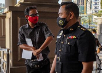 Mohd. Johan Fazlan Sa'don (kiri) hadir ke Mahkamah Sesyen Kuala Lumpur bagi menghadapi tuduhan mengemukakan tuntutan bekerja lebih masa palsu.
