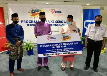 MAHDZIR Khalid (dua, kiri) menyampaikan replika sumbangan bantuan persekolahan pelajar Terengganu kepada Ahmad Said (dua, kanan) pada Program Ceria Ke Sekolah Tenaga Nasional Berhad (TNB) 2021 di Kuala Nerus hari ini. UTUSAN/TENGKU DANISH BAHRI TENGKU YUSOFF